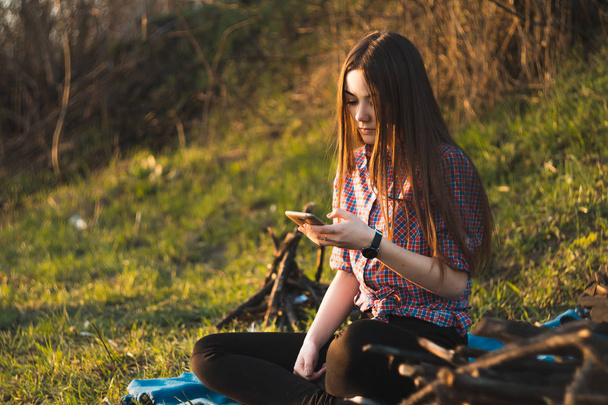 Mooi meisje zitten bij het haardvuur op een picknick in de summ - Foto, afbeelding