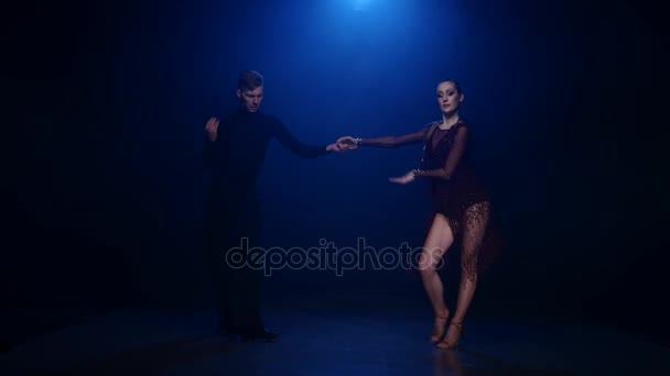 Salsa dancing couple of professional elegant dancers on blue background - 映像、動画