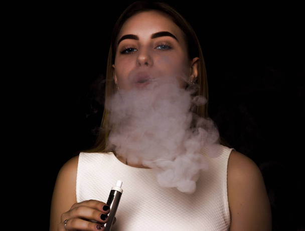 Pretty young girl uses electronic cigarette - Foto, imagen