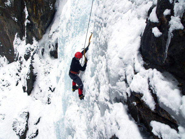 Homem escalando cascata congelada
 - Foto, Imagem