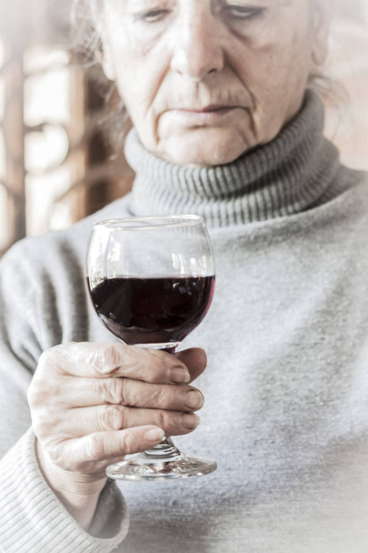 赤ワインのガラスを保持している悲しい女性 - 写真・画像