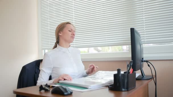 Kobieta Menedżer zmęczony z pracy robi ćwiczenia fizyczne przy stole w biurze - Materiał filmowy, wideo