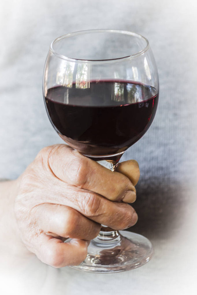 Woman's hand holding a glass of red wine - Photo, Image
