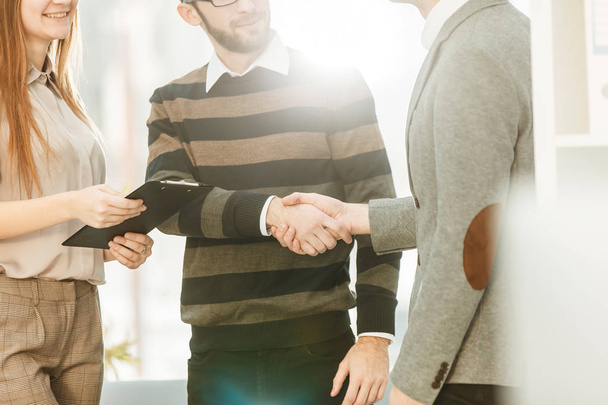 Manager shakes hands with the employee in a workplace in a modern office - Foto, Imagen