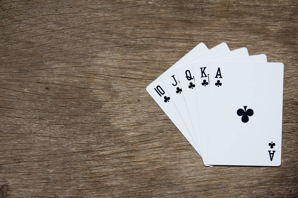 Viisi korttia musta klubi kuninkaallinen värisuora puinen tausta
 - Valokuva, kuva