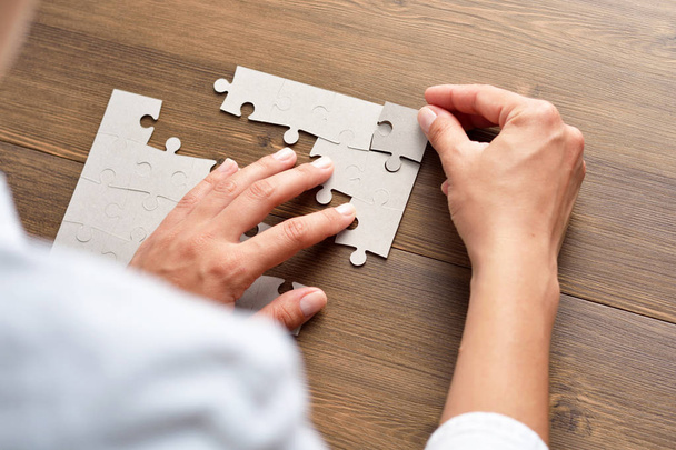 Close-up Of Businessman Hands Completing Jigsaw Puzzle - Zdjęcie, obraz