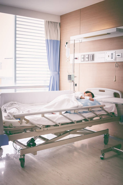 Азіатських хлопець лежав на sickbed з фізіологічним внутрішньовенно (Iv). Здоров'я  - Фото, зображення
