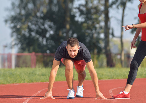 Sportos férfi pályán készen áll a futtatásra. Az aktív életmód egészséges fitness koncepció. - Fotó, kép