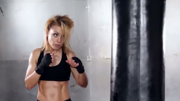 A beautiful and fit woman has a kickboxing training. Sport, health, concept. - Video
