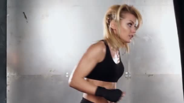 A beautiful and fit woman has a kickboxing training. Sport, health, concept. - Video