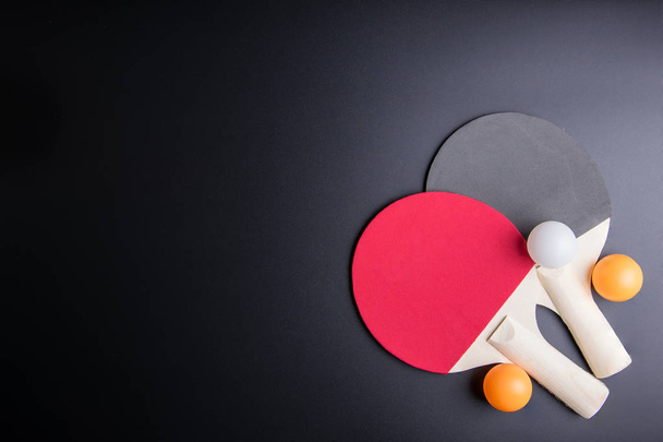 Raquete de tênis de mesa com ping pong ball em fundo preto.Spor
 - Foto, Imagem