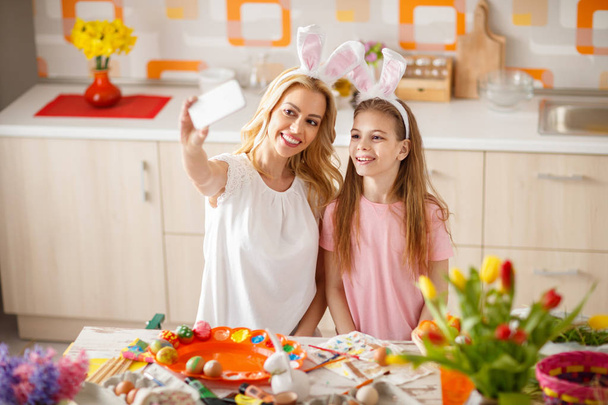 Woman with daughter make Easter selfie in kitchen - Fotó, kép
