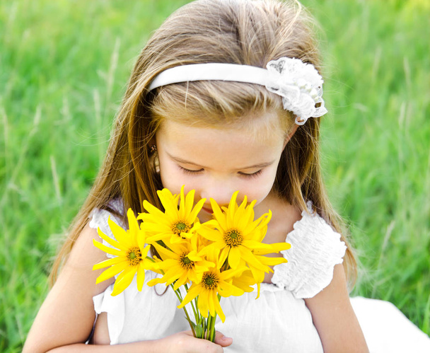 słodkie dziewczynki, pachnące kwiaty na łące  - Zdjęcie, obraz