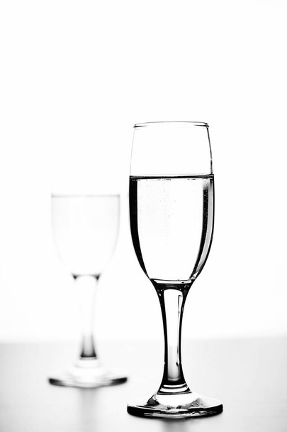 monochrome photo of champagne on white table on white background - 写真・画像