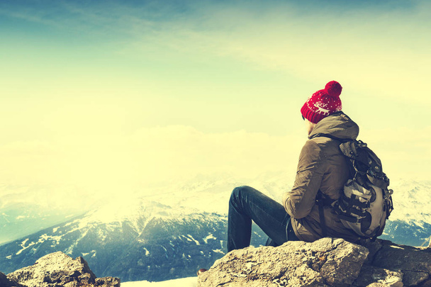 Jovem desportista ou viajante sentado em pedra e olhando no horizonte
 - Foto, Imagem