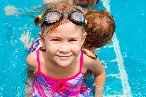 Happy little girl splashing around in the pool - Zdjęcie, obraz