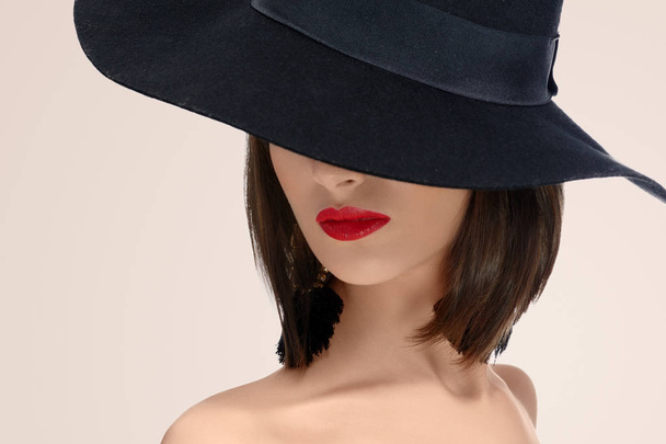 Elegant fashionable woman posing wearing a hat in studio - Fotoğraf, Görsel