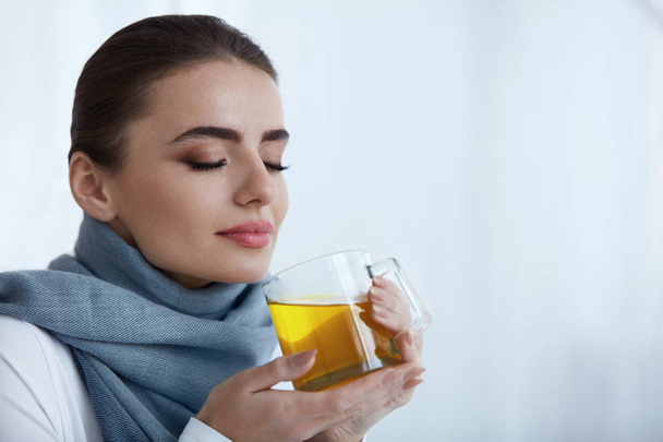 Beautiful Woman Drinking And Smelling Hot Warming Yellow Drink - Foto, Imagem