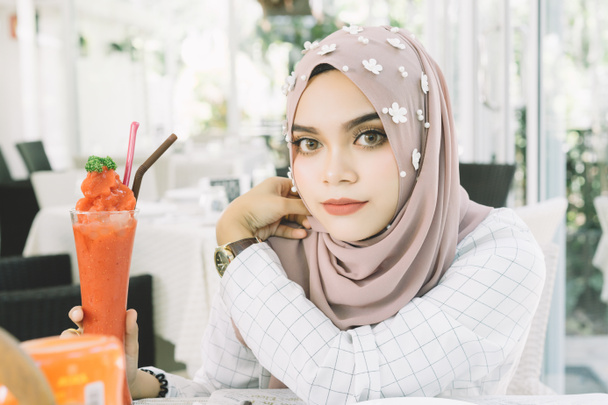young beautiful muslim woman with the Strawberry smoothie  in restaurant. - Photo, Image