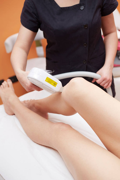 woman at cosmetics salon, legs laser epilation - Fotó, kép