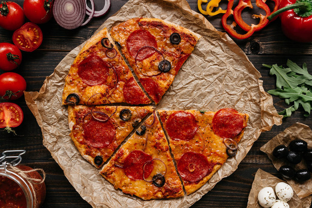 Fresh delicious pizza with pizza ingredients on the wooden table, top view - Foto, Imagen
