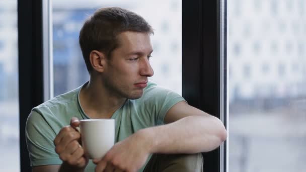 Χαλαρή hipster νέους πίνοντας καφέ κοντά στο παράθυρο - Πλάνα, βίντεο