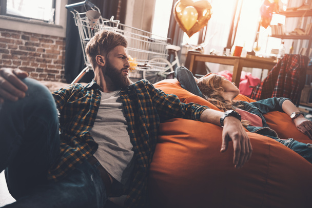 tired couple resting on beanbag chair  - 写真・画像
