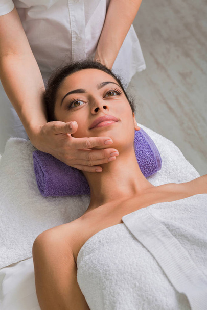 Massaggiatrice donna fanno massaggio lifting facciale nel centro benessere spa
 - Foto, immagini