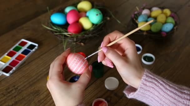 Female hands painting Easter eggs on dark wooden table. Selective focus. - Footage, Video