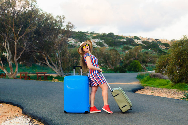 Joyeux rire jeune femme avec des valises sur la route
. - Photo, image