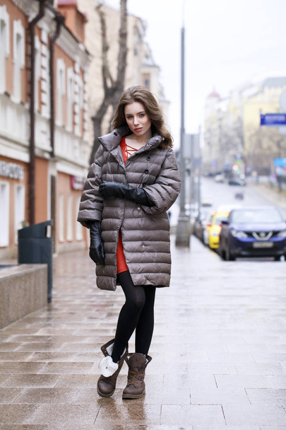 Portrait of a Young stylish brunette girl in a gray down jacket  - Zdjęcie, obraz
