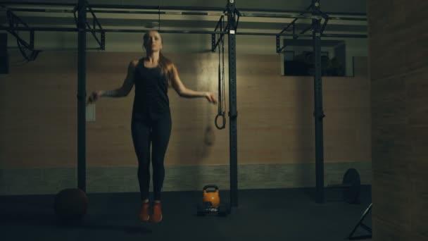 Woman jumping with a skipping rope in a gym - Video