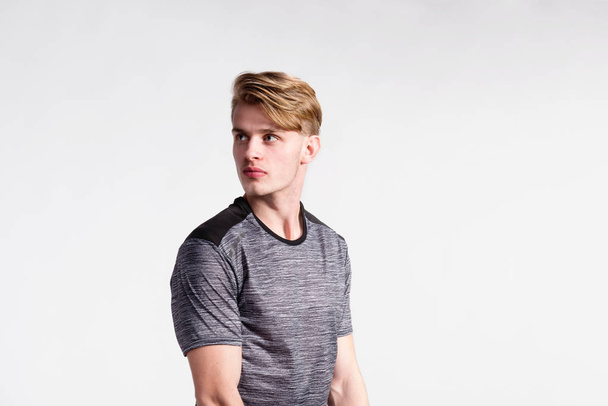 Young handsome hipster man in gray t-shirt, studio shot. - Foto, afbeelding