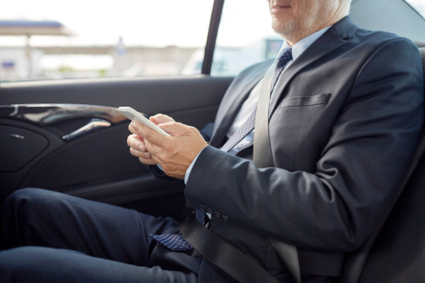 senior businessman texting on smartphone in car - Photo, image