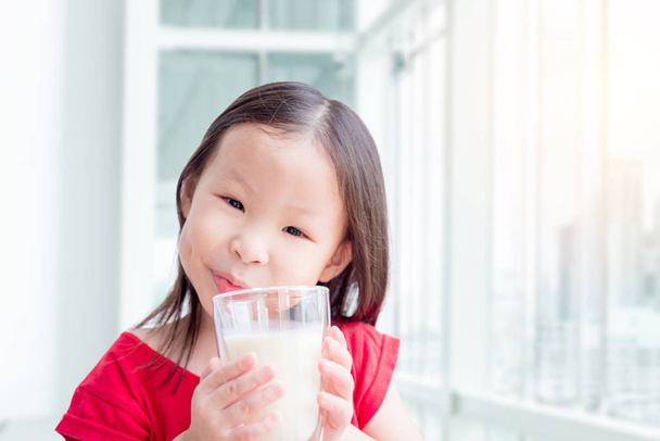 ミルクのガラスを飲む女の子 - 写真・画像