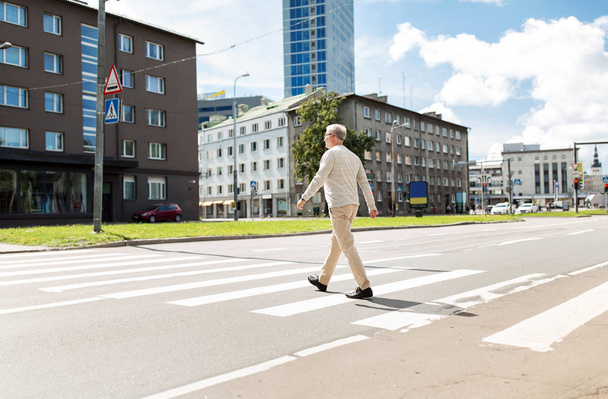 市内横断歩道を歩いている年配の男性 - 写真・画像