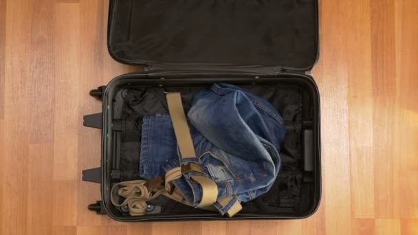 Widok z góry timelapse pakowania ubrań do walizki - Materiał filmowy, wideo