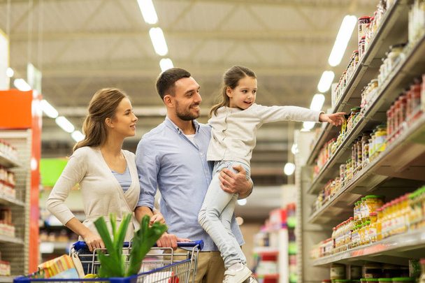 family with food in shopping cart at grocery store - Photo, image