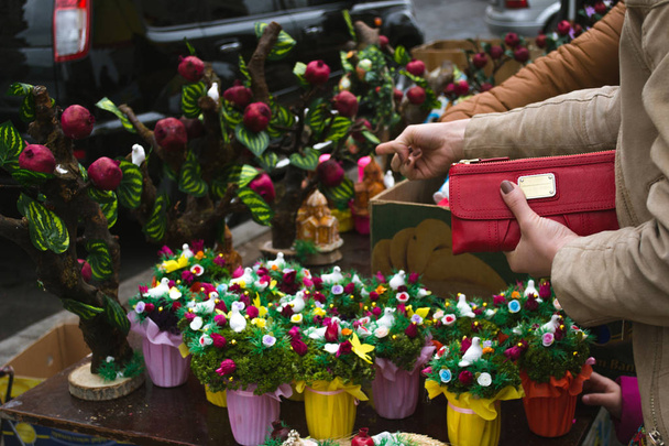 Obchodní koncepce. Nakupovat na trhu. Ženská ruka drží peněženku. Tradiční velikonoční trhy v Jerevanu. Velikonoční dekorace. Maloobchod - Fotografie, Obrázek