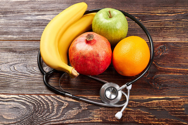 Stethoscope and fruits on wood. - Photo, Image