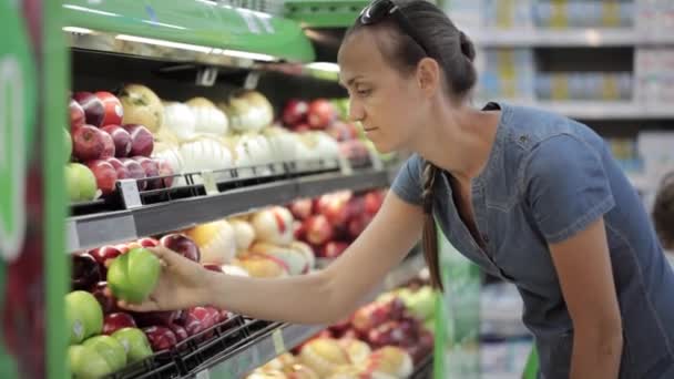 Woman selecting fresh apples in grocery store - Felvétel, videó