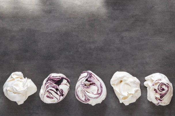 White and purple swirl meringues on gray background - Photo, Image