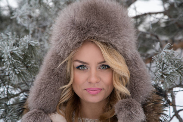 Winter portrait of beautiful smiling woman with snowflakes in white furs - Foto, imagen