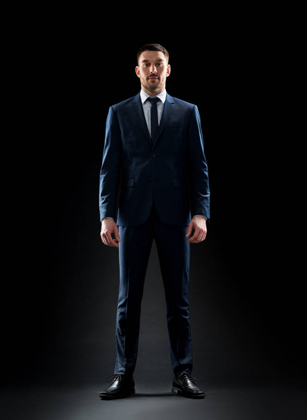 businessman in suit over black - Fotoğraf, Görsel