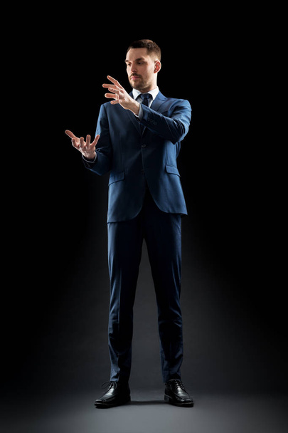 businessman in suit touching something invisible - Valokuva, kuva