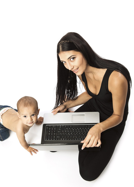 genç güzel kadın ve küçük çocuk beyaz bitti. bir laptop tutan kadın. - Fotoğraf, Görsel