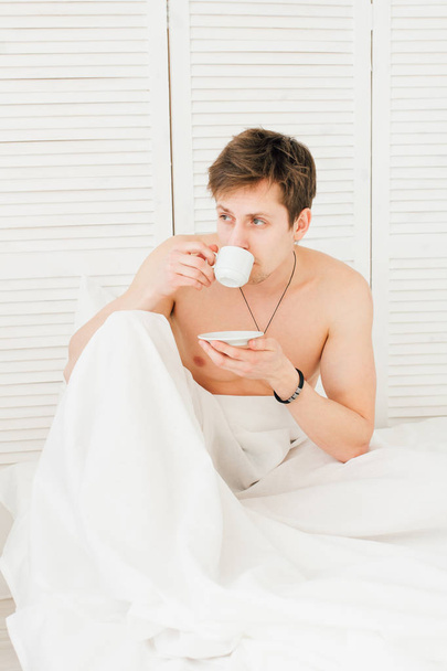 Man drinking coffee at Breakfast in bed  - Фото, изображение