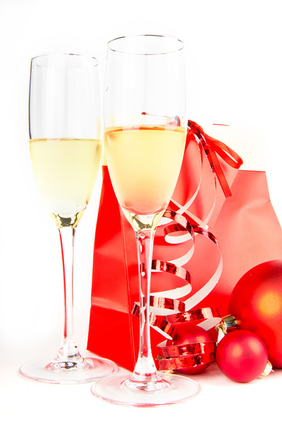 Two glass goblets with champagne, Christmas balls and present on white background - Foto, immagini