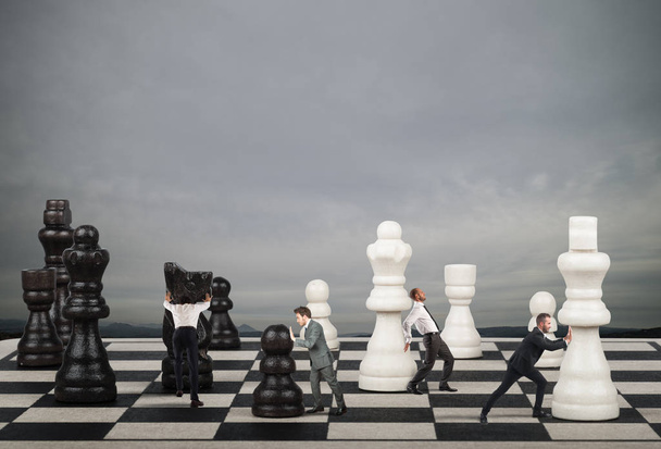 Бизнесмены перемещают шахматные фигуры
.  - Фото, изображение