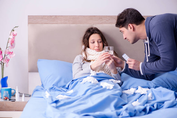 Жена ухаживает за больным мужем дома в постели - Фото, изображение